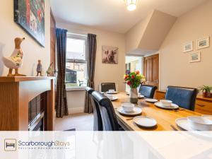 a dining room with a table and chairs around it at Mayville Lodge - STUNNING 3 BEDROOMED TOWNHOUSE WITH FREE PARKING in Scarborough