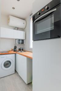 eine Küche mit einem Herd, einer Waschmaschine und einem Trockner in der Unterkunft Bel appartement tout équipé de 24m2, proche Paris in Nanterre