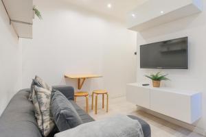 ein Wohnzimmer mit einem Sofa und einem Flachbild-TV in der Unterkunft Bel appartement tout équipé de 24m2, proche Paris in Nanterre