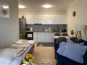 a living room with two beds and a kitchen at Apartament Mielczarskiego Tanie spanie Elbląg in Elblag