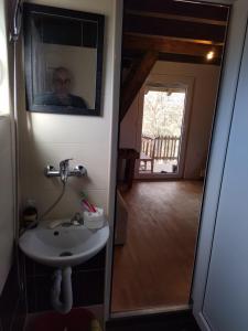 a man taking a picture of a bathroom with a sink at Vikendica Varosiste Rogatica in Rogatica