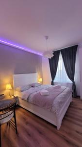 a bedroom with a large bed with purple lighting at Clar studio 1 in Braşov