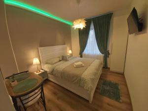 a bedroom with a bed with a green light at Clar studio 1 in Braşov