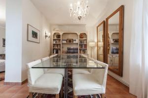 uma sala de jantar com uma mesa de vidro e cadeiras brancas em Luxury Villa in Alicante em Alicante