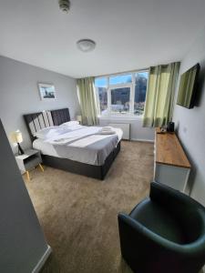 a bedroom with a bed and a desk and a chair at King's Knoll Hotel in Oban