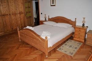 a bedroom with a wooden bed and a wooden floor at Incantevole appartamento in un Castello storico in Croviana
