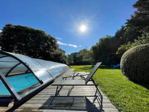 ein Picknicktisch und ein Zelt neben einem Pool in der Unterkunft Le gîte Marie-Galante : Belle maison d'hôtes avec accès piscine en été in Lanmeur