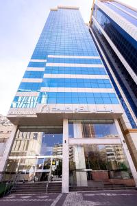 a tall building with blue glass windows and stairs at فندق منار التوحيد 1 in Makkah