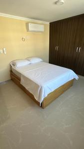 a bedroom with a large bed with white sheets at Apartamento Amoblado Barranquilla San Jose in Barranquilla