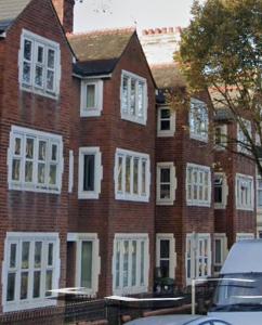 een groot rood bakstenen gebouw met witte ramen bij Nariken Apartments, Cardiff in Cardiff