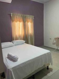 a bedroom with a white bed with a window at Casa privada, amplia y moderna. in Catacamas