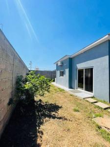 a blue building with a yard next to a wall at Casa privada, amplia y moderna. in Catacamas