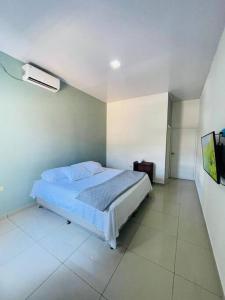 1 dormitorio con 1 cama y TV. en Casa privada, amplia y moderna., en Catacamas