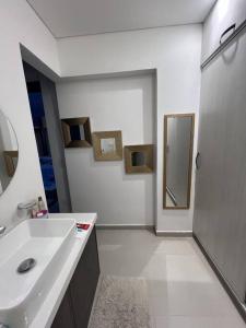 ein weißes Badezimmer mit einem Waschbecken und einem Spiegel in der Unterkunft Hermosa y Moderna Casa Campestre in La Mesa