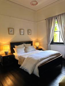 1 dormitorio con 1 cama grande y 2 lámparas en The Boston Ivy 1880 - The Residence, en Mittagong