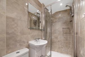 a bathroom with a toilet and a sink and a shower at Little Venice Studio By Morethanstays in London