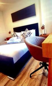 1 dormitorio con 1 cama con escritorio y silla en Watford Gem Private Garden Mins to Harry Potter Studio en Watford