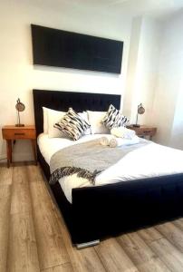 1 dormitorio con 1 cama con cabecero negro en Watford Gem Private Garden Mins to Harry Potter Studio en Watford