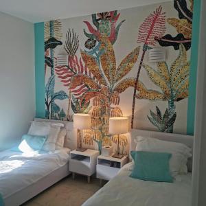 1 dormitorio con 2 camas y una pared con un mural en Blue Dream Cannes Guest House en Cannes