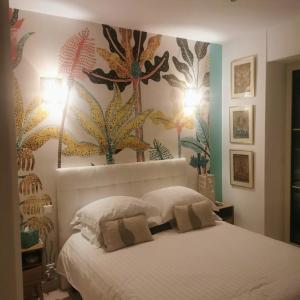 a bedroom with a white bed with flowers on the wall at Blue Dream Cannes Guest House in Cannes