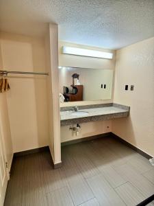 La salle de bains est pourvue d'un lavabo et d'un grand miroir. dans l'établissement Knights Inn Galax, à Galax