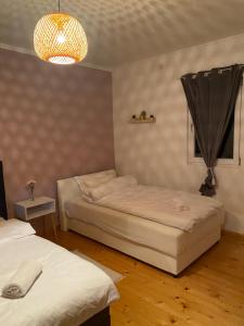 1 Schlafzimmer mit 2 Betten und einem Kronleuchter in der Unterkunft Kuca na kraju sela in Valjevo