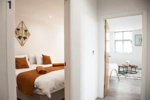 Cityscape 2-BR - Leicester's Premier Urban Retreat في ليستر: غرفة نوم بسرير وغرفة مع طاولة