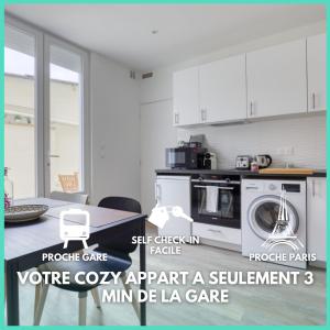 a white kitchen with a microwave and a table at Cozy Appart 4 Proche gare - Cozy Houses in Palaiseau