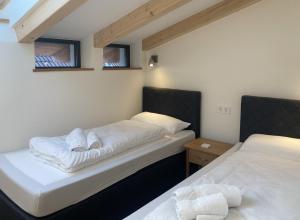 a room with two beds and two windows at Filder-Appartements in Filderstadt