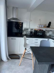 a kitchen with a black counter top and a microwave at CHILL HOME- T2 Aménagé in Sainte-Suzanne