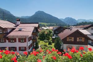 eine Gruppe von Häusern in einem Dorf mit roten Blumen in der Unterkunft Hotel Garni Regina in Oberstdorf