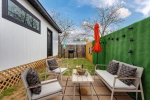a patio with two chairs and a green wall at Hidden Cottage mins to Main St and sleeps 4 in Fredericksburg