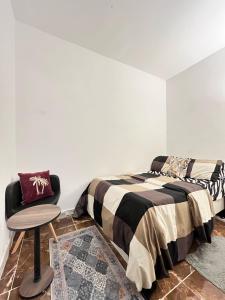 ein Schlafzimmer mit einem Bett und einem Stuhl in der Unterkunft Tanih's Lodging in Abu Dhabi