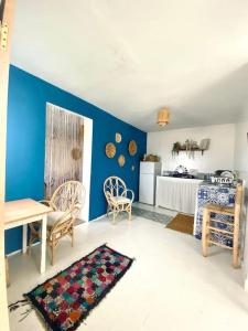 een woonkamer met een tafel en een blauwe muur bij apartment a ksar sghir in front Tanger Med ferry port in Agaouz