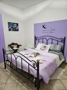 un letto in una camera da letto con parete viola di RAGGIO DI LUNA a Montefiascone