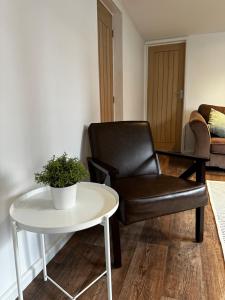a chair and a table in a living room at Entire Apartment with super king size bed close to Town Centre in Colchester