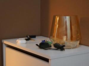 a white table with a lamp and some items on it at Lys og hyggelig leilighet, 3- roms på Solsiden in Trondheim