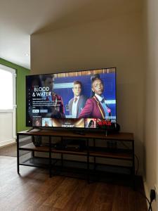 a flat screen tv sitting in a living room at Entire Apartment super king bed close to Town Centre in Colchester +16 photos