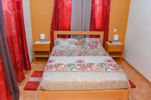 sypialnia z 2 łóżkami i czerwonymi zasłonami w obiekcie Paris Hotel w mieście Praia