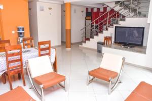 a waiting room with chairs and a tv and stairs at Paris Hotel in Praia