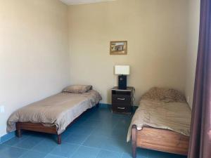 2 camas en una habitación con suelo de baldosa azul en Dpto en plena plaza principal en Tarija, en Tarija