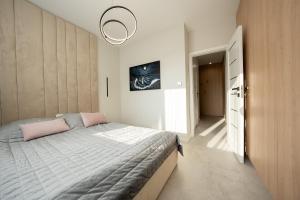 a small bedroom with a bed and a hallway at Apartament z Tarasem Morska 6 Rewal 50m do morza in Rewal