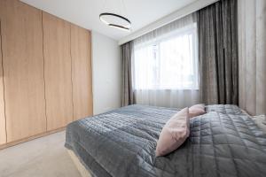a bedroom with a bed and a window at Apartament z Tarasem Morska 6 Rewal 50m do morza in Rewal