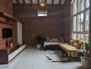 a living room with a couch and a tv at Red Rock Villa, Virajpet, Coorg in Virajpet