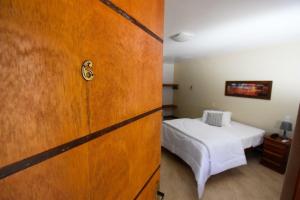 a room with a bed and a wooden door at Pousada Paris Hostelli in Penedo