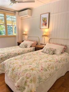 a bedroom with two beds and two tables with lamps at Noosa Hinterland Escape in Black Mountain