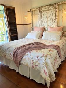 um quarto com uma cama grande com lençóis cor-de-rosa e brancos em Noosa Hinterland Escape em Black Mountain