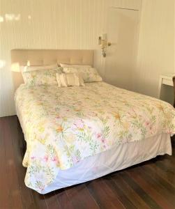 a bedroom with a large bed with a floral bedspread at Noosa Hinterland Escape in Black Mountain