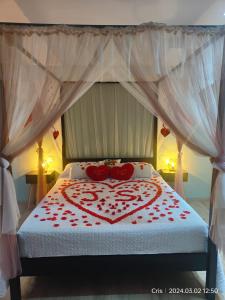 una camera da letto con un letto con cuori rossi sopra di Le relax a La Louvière