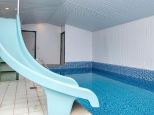 a swimming pool with a slide in a bathroom at Holiday home Rømø XV in Bolilmark